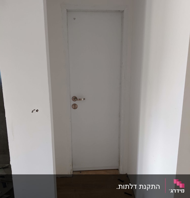 דלת לבנה עם ידית מתכת, קיר לבן